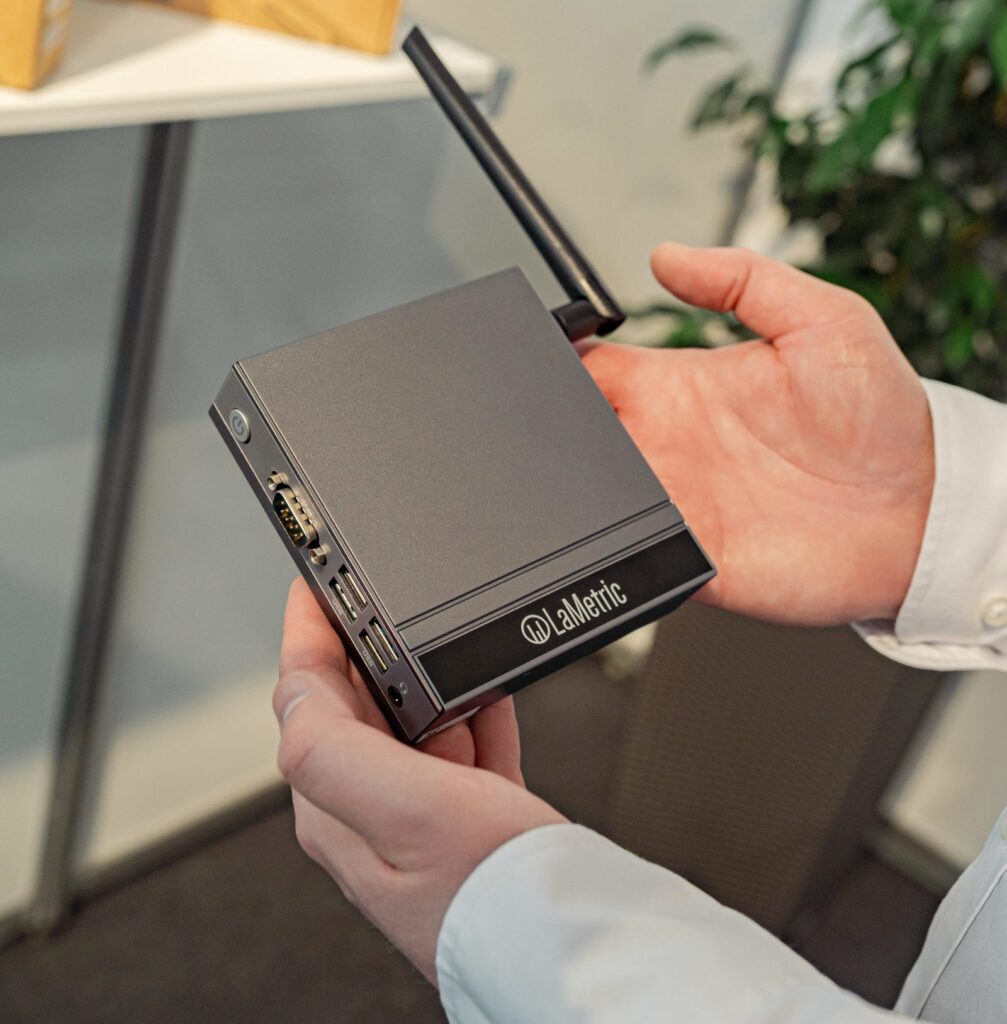 LaMetric Edge Box media player held in hand, with antenna, serial and USB ports