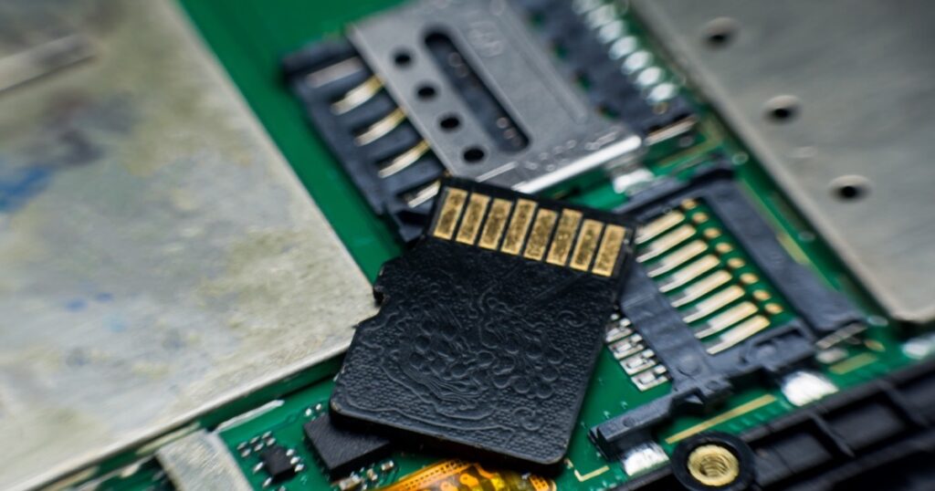 MicroSD card next to its slot on a circuit board