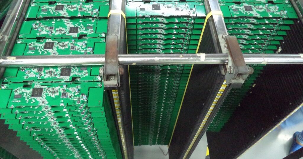 Assembled circuit boards in magazine racks on the production line