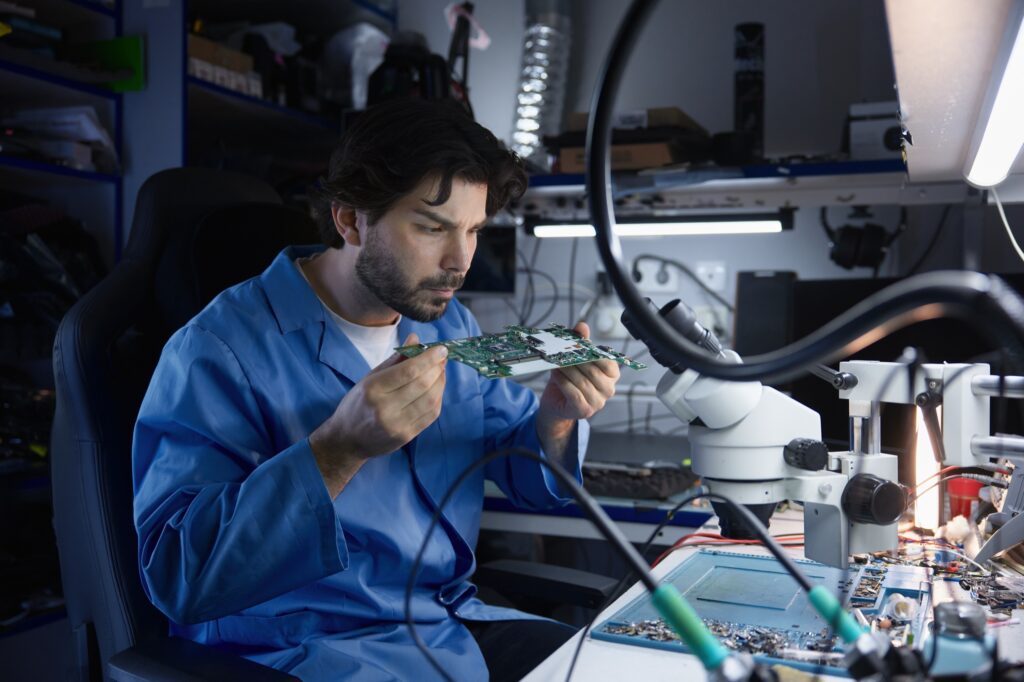 Engineer analysing a circuit board in a lab