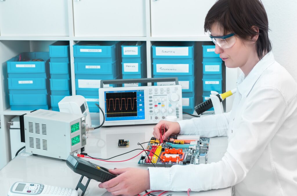 Technician testing an electronic device with lab instruments