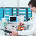 Technician testing an electronic device with lab instruments