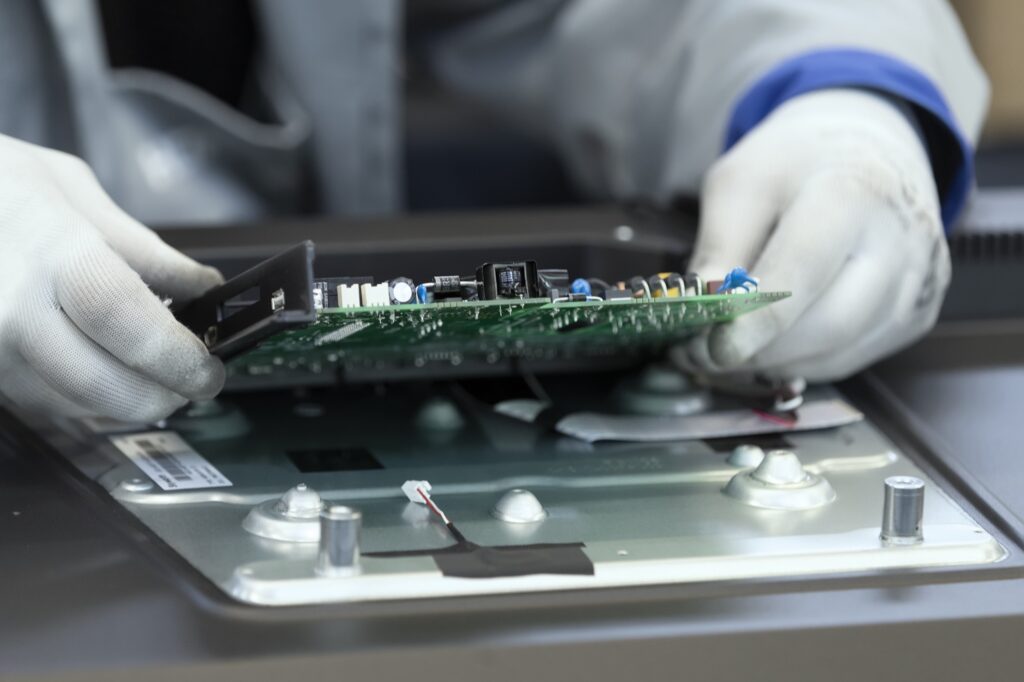 Technician handling a circuit board on a production line
