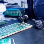 Engineer working on printed circuit board panels in an electronics lab
