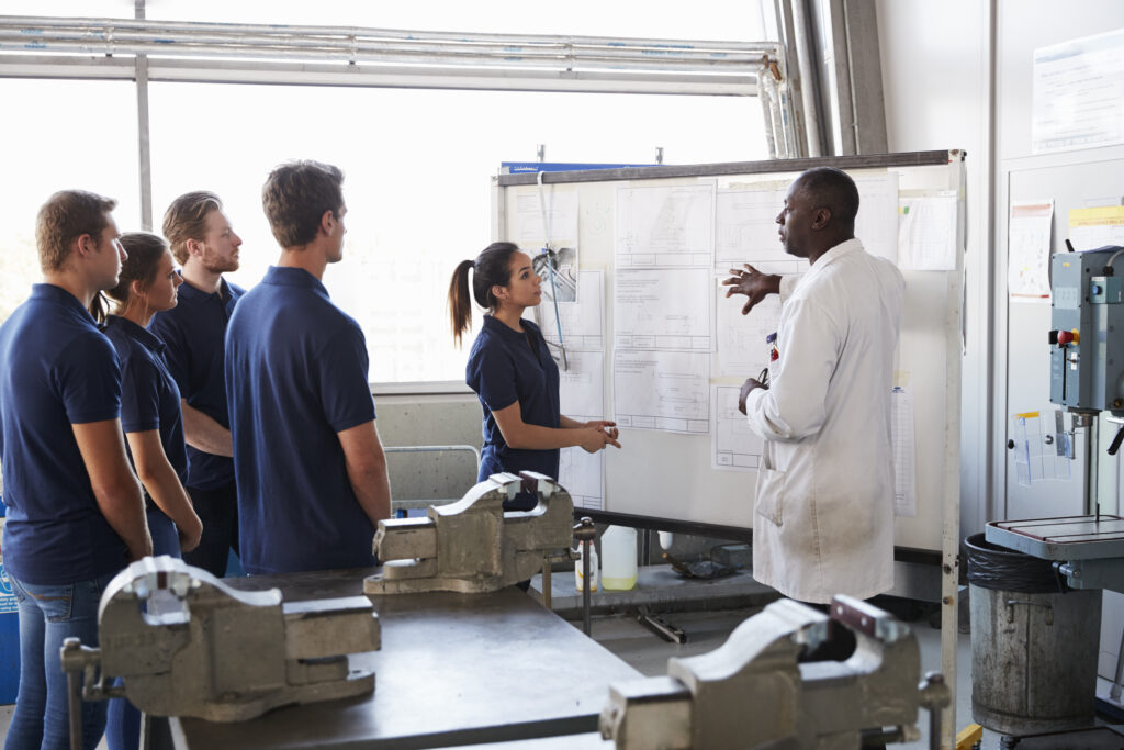 Engineer and female apprentice presenting at whiteboard