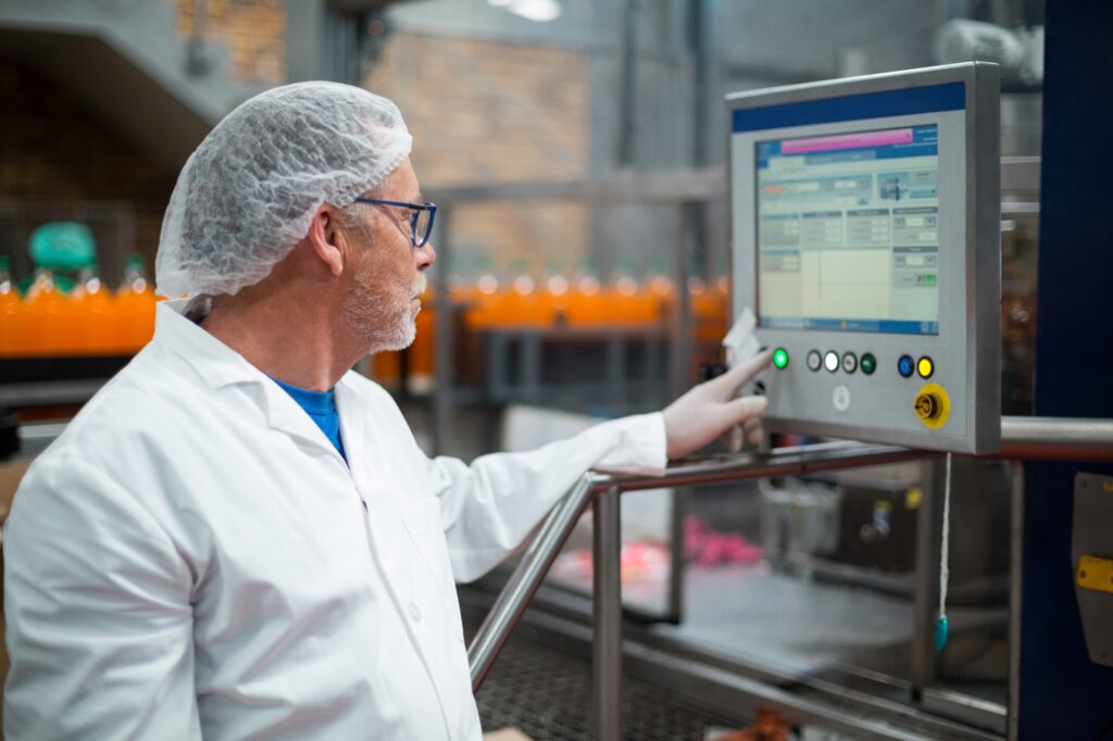 Operator using an industrial HMI touch panel on a food production line