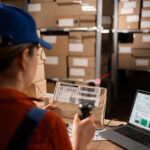 Woman worker working with warehouse management system with b