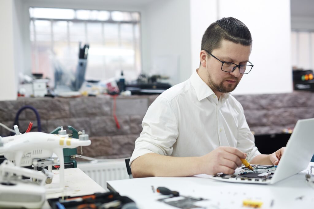 Engineer working on electronics with test equipment