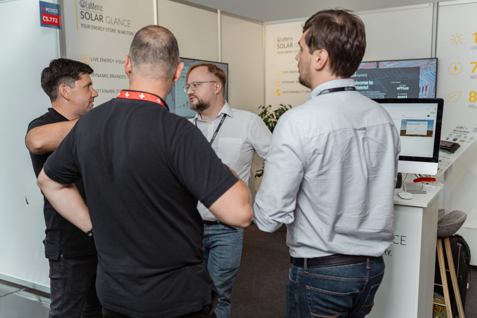 Smart Atoms engineers discussing LaMetric Solar Glance with visitors at a trade fair booth