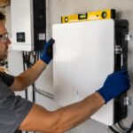 Technician installing a solar inverter on a wall
