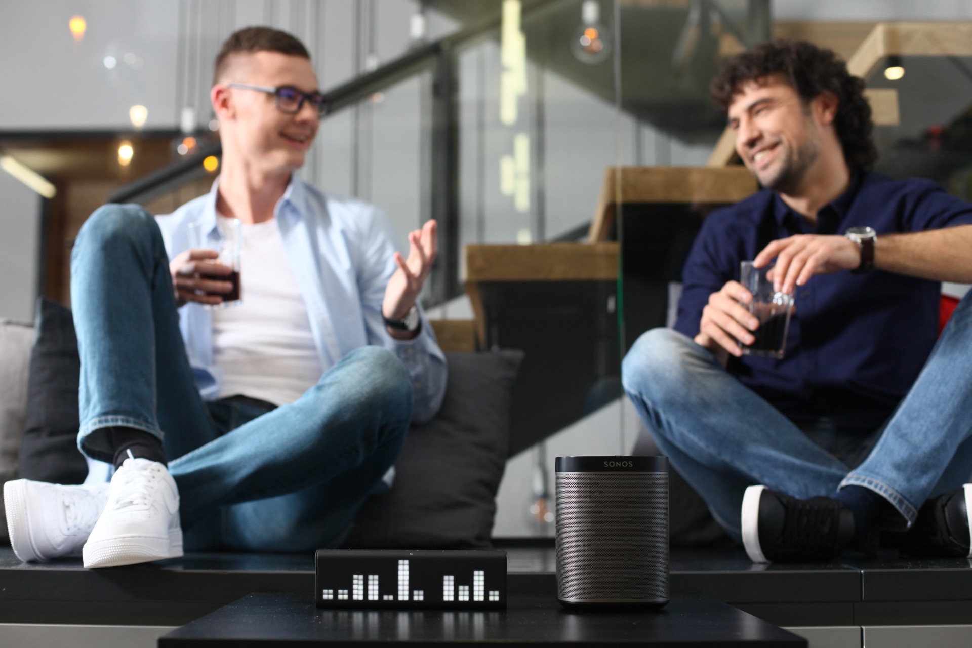 LaMetric TIME on a table while two people chat