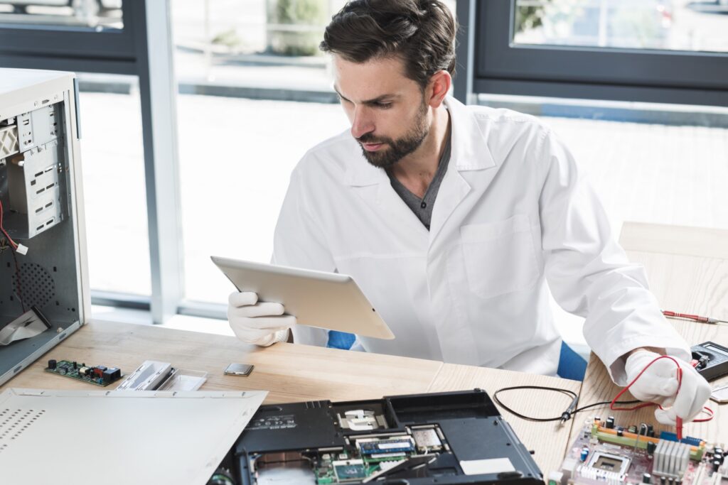 Engineer reviewing a device on a tablet in a workshop
