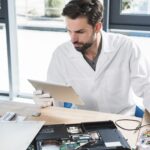 Engineer reviewing a device on a tablet in a workshop
